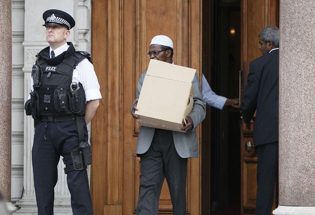 A worker carries a box from the Libyan embassy in Knightsbridge, London, after staff were told to leave last month
