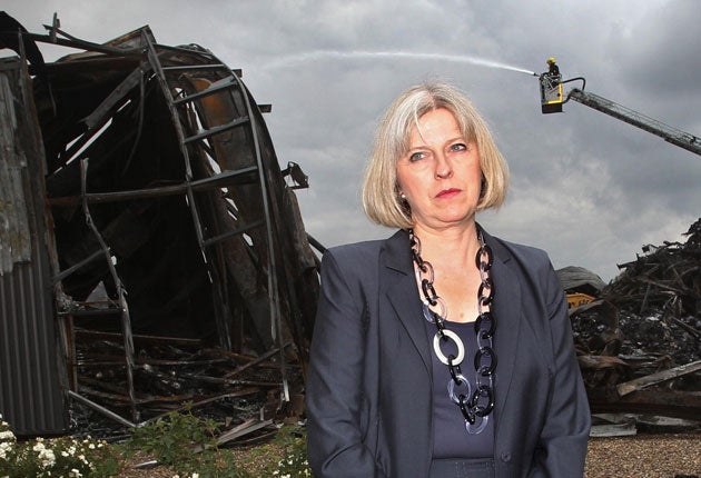 The Home Secretary, Theresa May, visits the burnt-out remains of a Sony distribution warehouse in Enfield yesterday