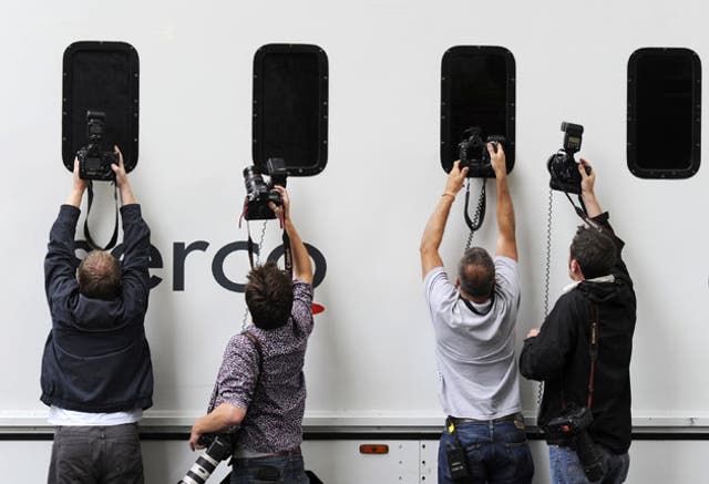 Press photographers snap a prison van leaving City of Westminster Magistrates' Court yesterday