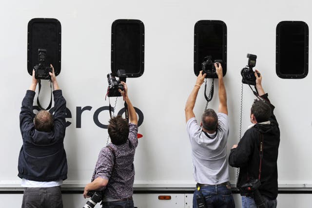Press photographers snap a prison van leaving City of Westminster Magistrates' Court yesterday