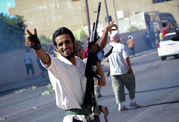 A rebel soldier flashes a victory sign as he enters the western outskirts of Zawiyah