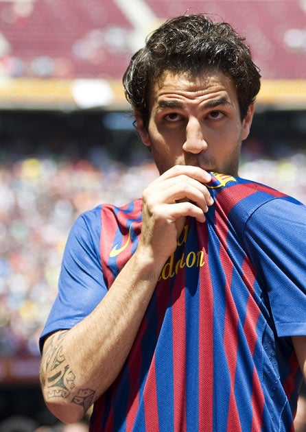 Fabregas kisses the badge as he is unveiled by Barcelona inside the Nou Camp