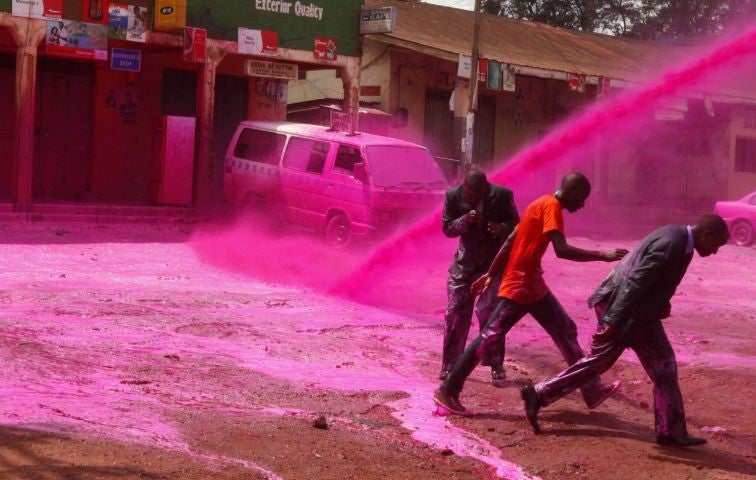 Opposition supporters are sprayed with coloured paint in Uganda