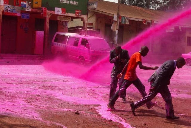 Opposition supporters are sprayed with coloured paint in Uganda