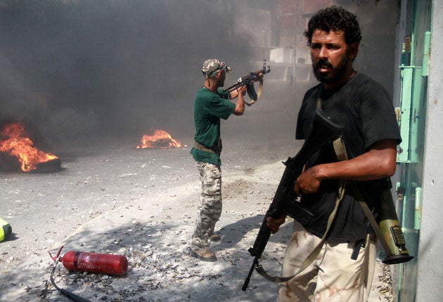 Libyan rebel fighters fire at regime forces during the battle for control of Zawiya