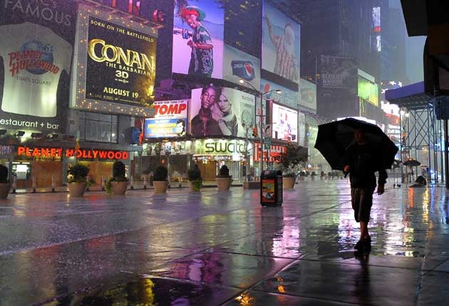 A person makes their way in the rain in Times Square in New York