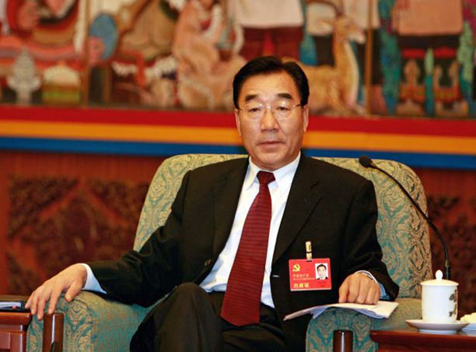 Former Tibet Communist Party chief Zhang Qingli sits in front of a Tibetan wall painting