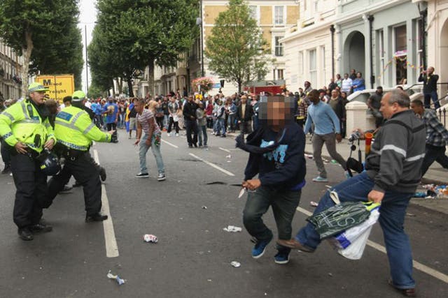 In an extraordinary picture, the young man, left of centre, wearing faded jeans and a red and white stripey top, looks astonished as he realises he has been stabbed in the abdomen and hand.