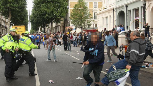 In an extraordinary picture, the young man, left of centre, wearing faded jeans and a red and white stripey top, looks astonished as he realises he has been stabbed in the abdomen and hand.