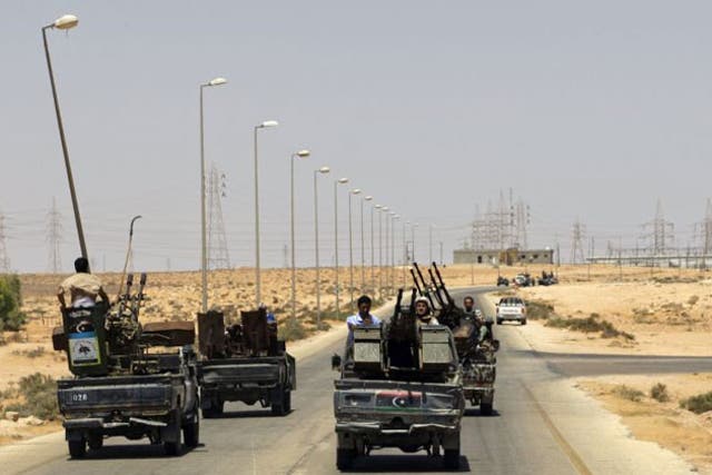 Rebel fighters patrol the road near the village of Heisha