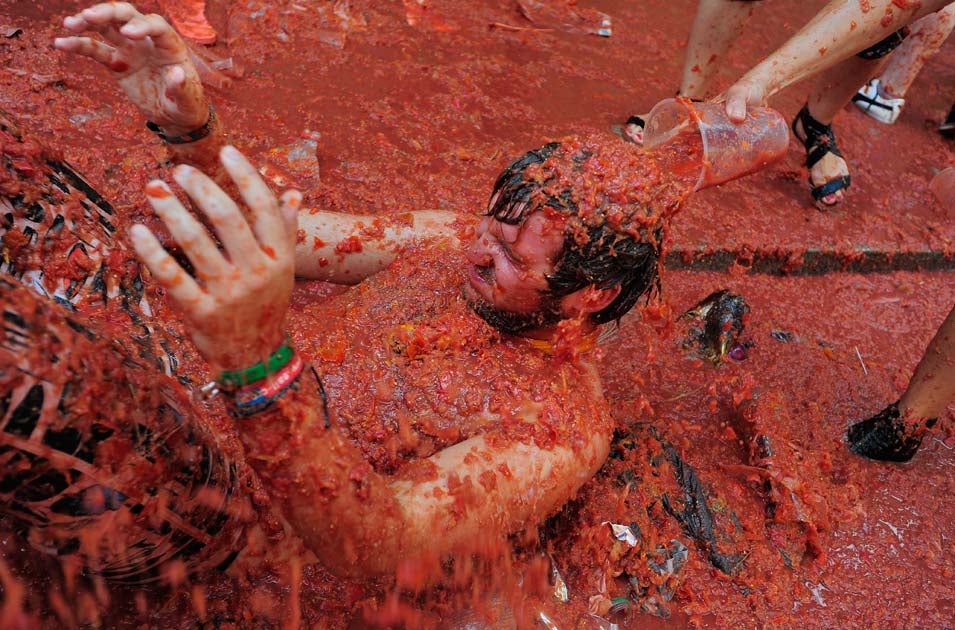 A reveller is covered in tomato pulp and juice while participating in the annual Tomatina festival on August 31, 2011 in Bunol, Spain. An estimated 35,000 people threw 120 tons of ripe tomatoes in the world's biggest tomato fight held annually in this Spanish Mediterranean town.