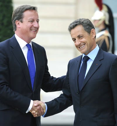 David Cameron is welcomed by France's president Nicolas Sarkozy prior to meeting members of Libya's National Transitional Council (NTC) in Paris 2010