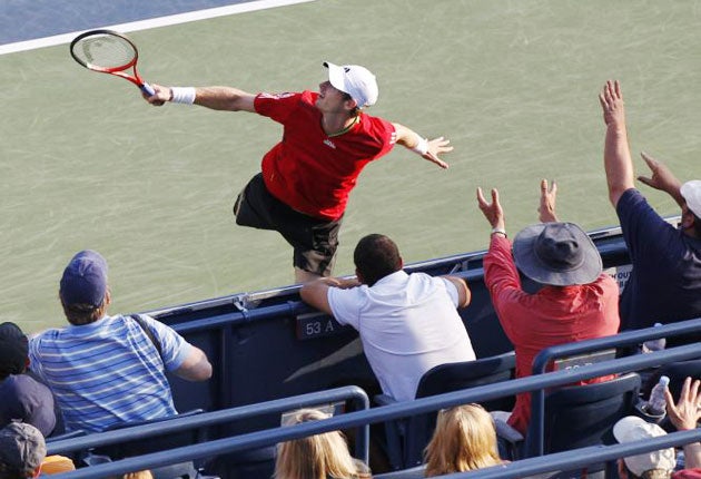 Fans in Louis Armstrong Stadium put their arms up as Andy Murray, of Great Britain, runs close to the back wall to return to Robin Haase