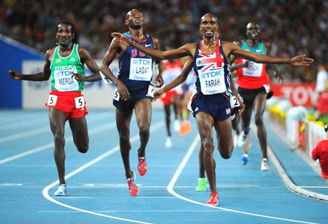 Mo Farah arrives at the finish line ahead of US athlete Bernard Lagat and Ethiopia's Imane Merga to win the men's 5,000 metres final