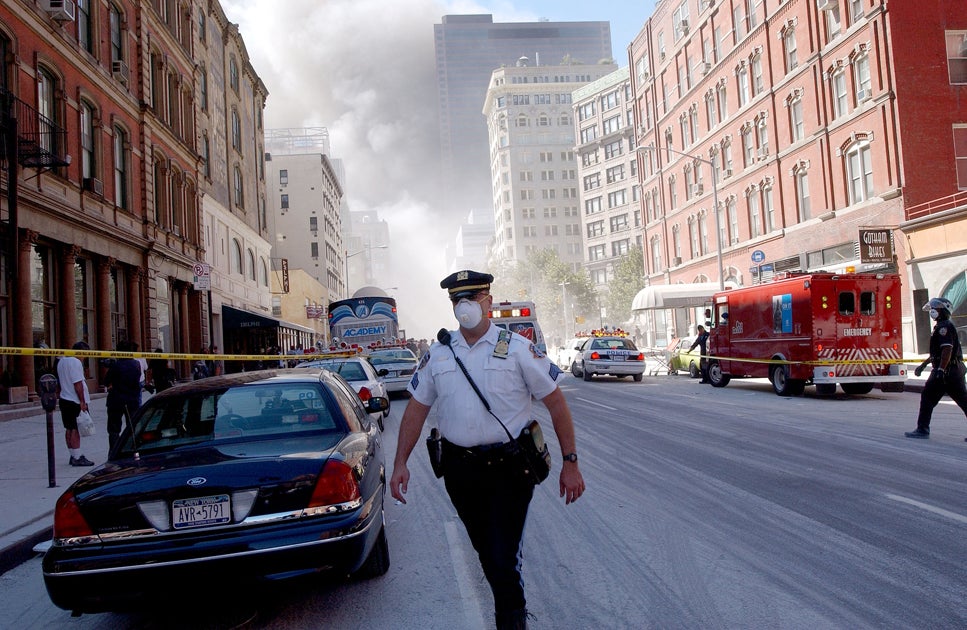 A police officer patrols in the street after the collapse of the World Trade Center towers September 11, 2001 in New York City after two airplanes slammed into the twin towers in a suspected terrorist attack