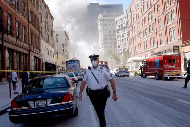 <p>A police officer patrols in the street after the collapse of the World Trade Center towers September 11, 2001 in New York City after two airplanes slammed into the twin towers in a suspected terrorist attack</p>