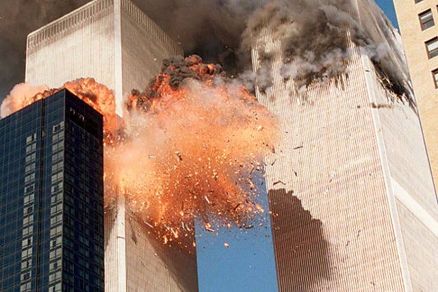 Smoke billows from one of the towers of the World Trade Center and flames and debris explode from the second tower
