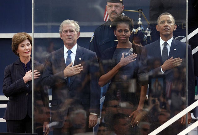 Former first lady Laura Bush, from left, former President George W. Bush, first lady Michelle Obama and President Barack Obama hold hands to their hearts during the national anthem at the World Trade Centre site
