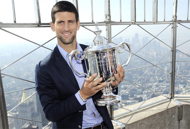 Novak Djokovic poses with his latest Grand Slam trophy on the observation deck of the Empire State Building