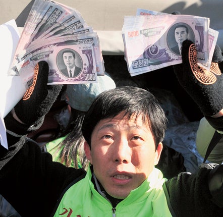 Park Sang-hak holding banknotes that he sent to North Korea by balloon in a protest against Kim Jong-il