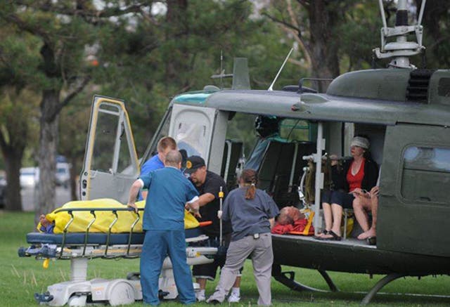 Medics help injured bystanders out of a helicopter into Renown Medical Center