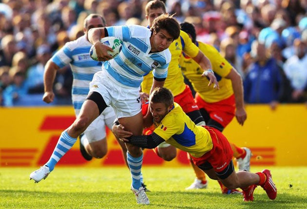 Florin Surugiu of Romania tackles man of the match Argentina's Lucas Gonzalez Amorosino