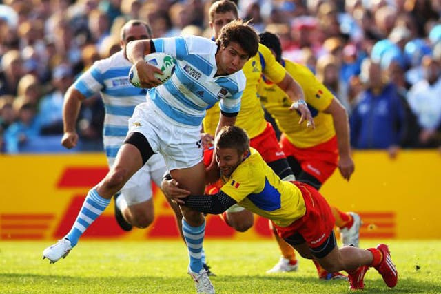 Florin Surugiu of Romania tackles man of the match Argentina's Lucas Gonzalez Amorosino