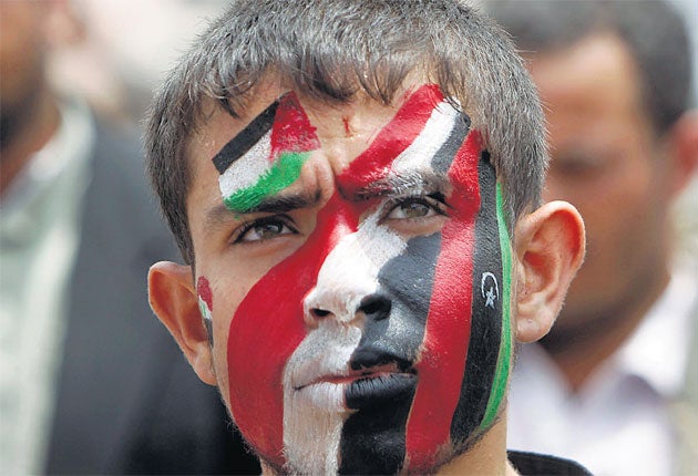 A protester in the Yemeni capital, Sanaa, wears the colours of Syria, Libya, Yemen and the Palestinians