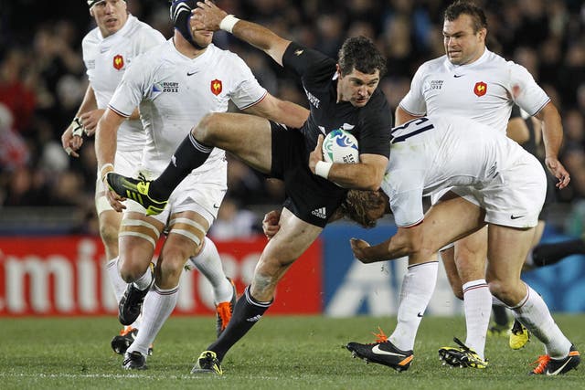 Stephen Donald is tackled by France's Aurélien Rougerie yesterday