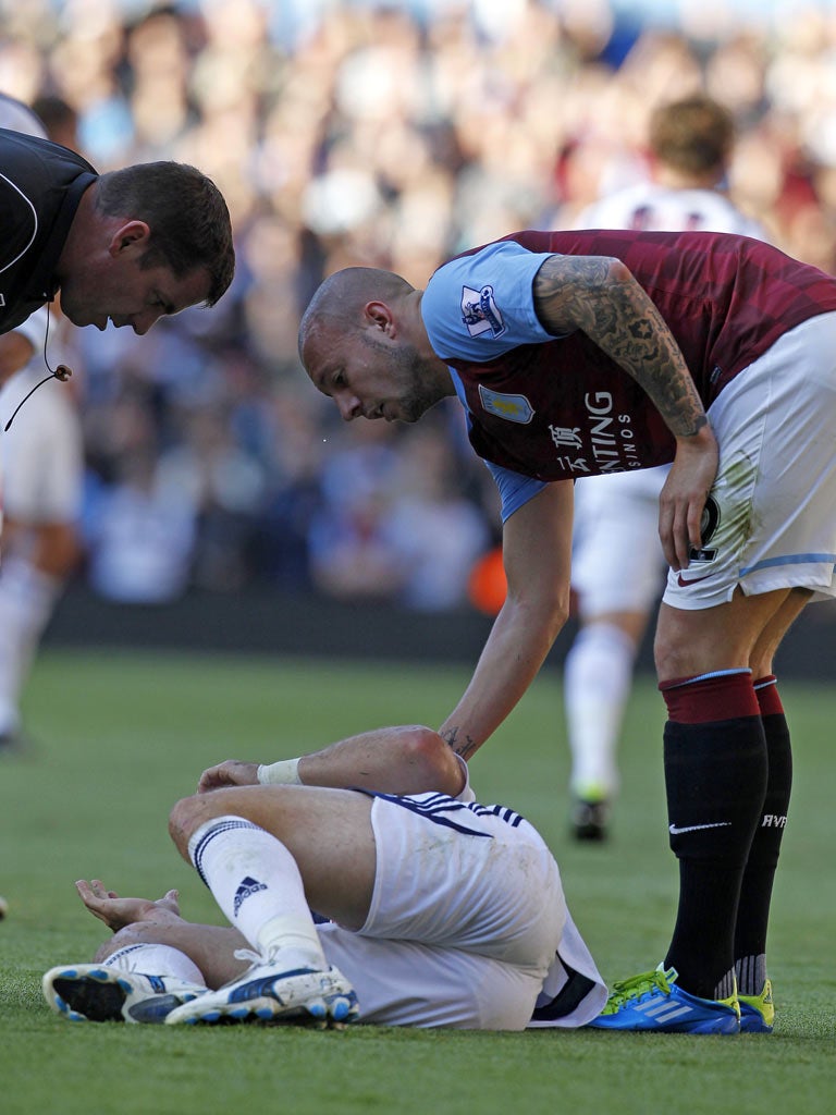 Alan Hutton and referee Phil Dowd show concern over Shane Long