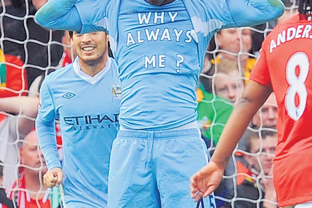 Mario Balotelli reveals his 'Why Always Me?' T-shirt at Old Trafford. He won't be wearing another one though: 'No, because otherwise I'll get booked every week,' he grinned
