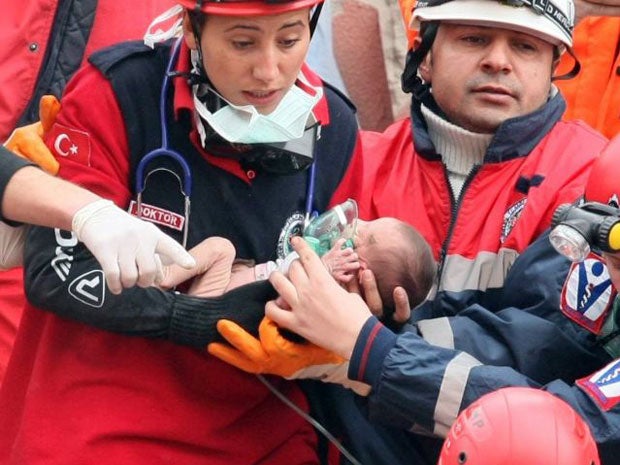 Rescue workers hold Azra Karaduman, a two-week-old baby who was pulled from the debris of the earthquake