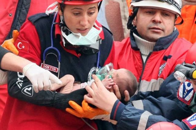 Rescue workers hold Azra Karaduman, a two-week-old baby who was pulled from the debris of the earthquake
