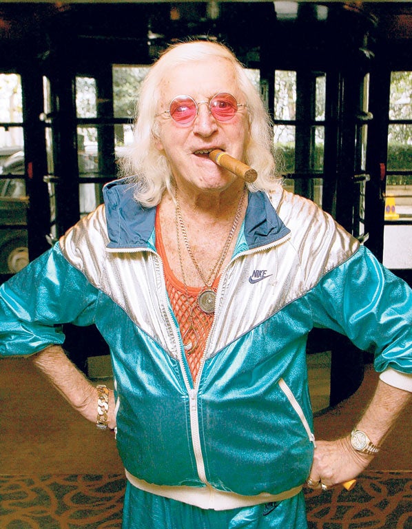 With his trademark dyed hair cigar and jewellery, Jimmy Savile, seen here in December 2006, helped to raise more than £30m for charities