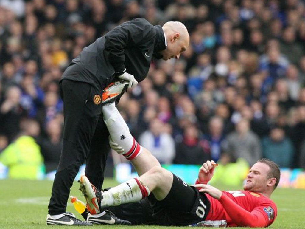 Manchester United's new midfielder Wayne Rooney feels the pain of a busy afternoon