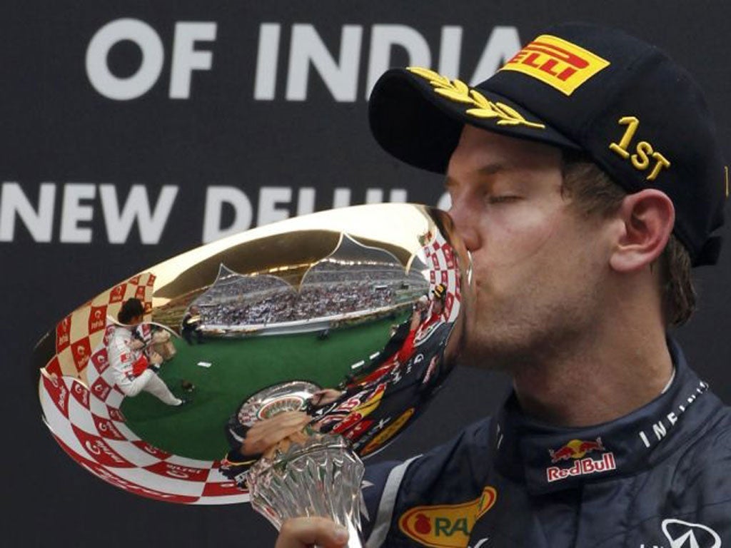 Victorious Red Bull star Sebastian Vettel kisses his trophy in India