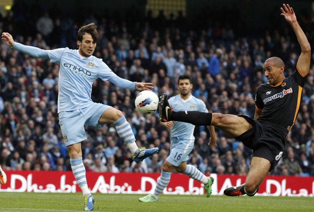 Wolves midfielder Karl Henry (right) goes full stretch to stop Manchester City's David Silva at Eastlands on Saturday
