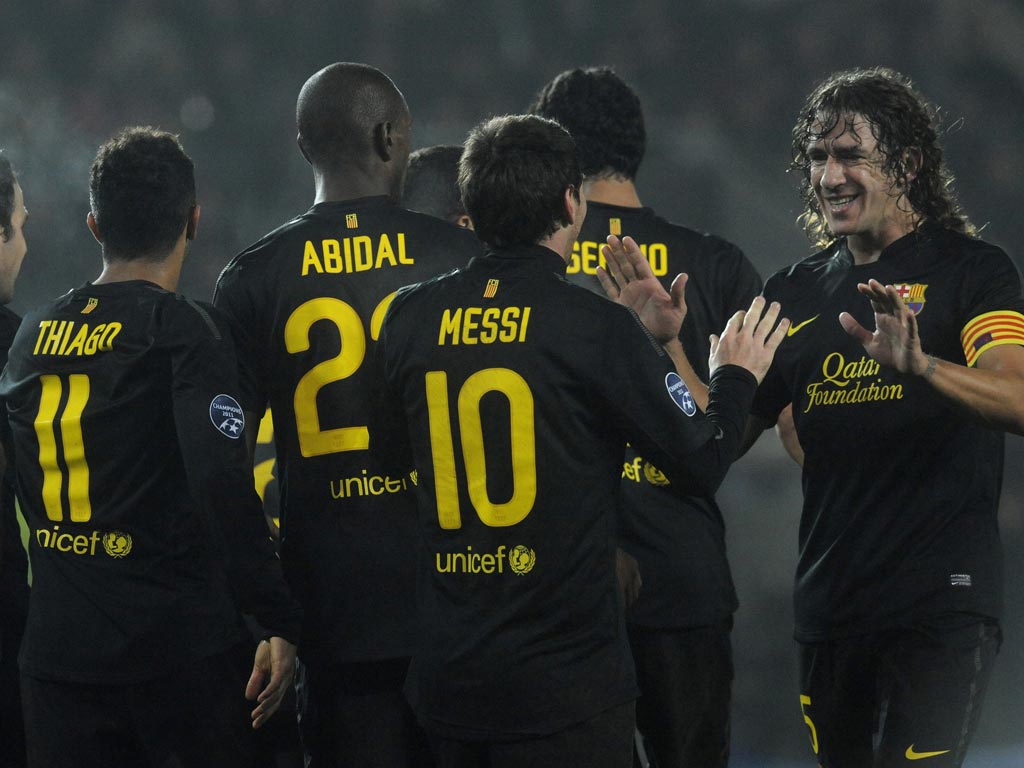 Messi is congratulated by his captain Carles Puyol