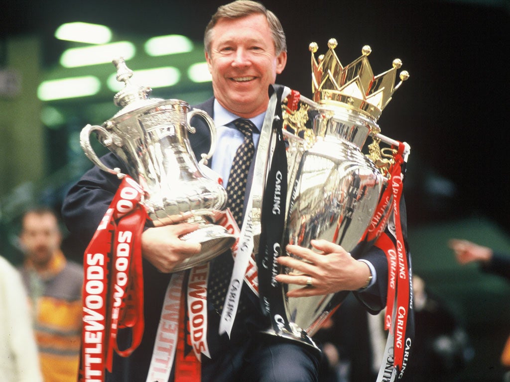 Sir Alex Ferguson with the FA Cup and Premier League trophies in 1996