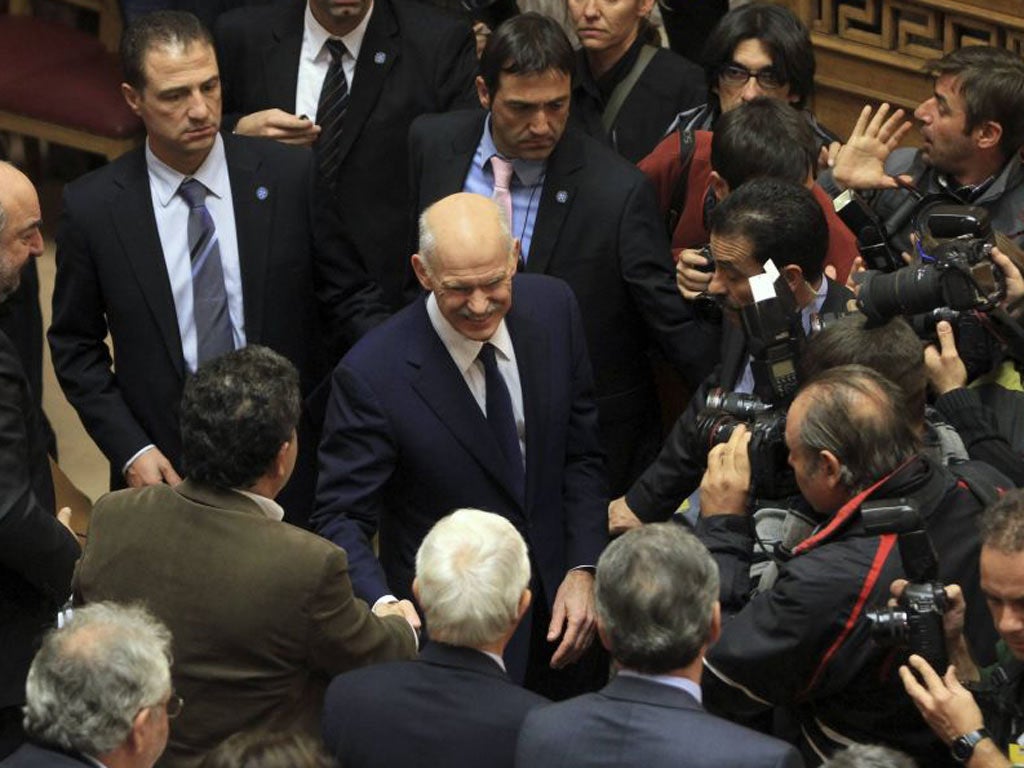 The Greek Prime Minister George Papandreou is greeted by Socialist MPs in parliament yesterday