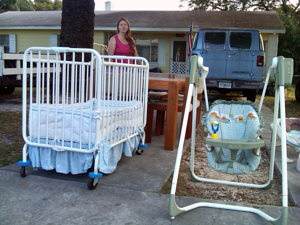 Financially strapped Renee Sullivan holds a yard sale outside her home in Lakeland, Florida, which she is renting out while she moves into a smaller flat