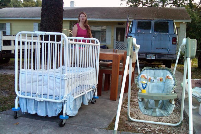 Financially strapped Renee Sullivan holds a yard sale outside her home in Lakeland, Florida, which she is renting out while she moves into a smaller flat