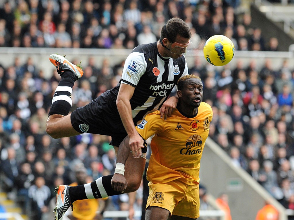 Masked hero: Newcastle's Steven Taylor leaps in to challenge Louis Saha