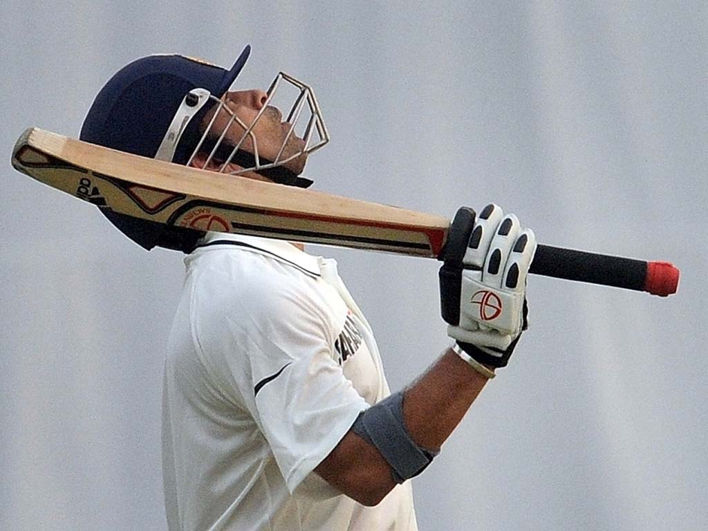 Tendulkar raises his bat after reaching the milestone of 15,000 runs
