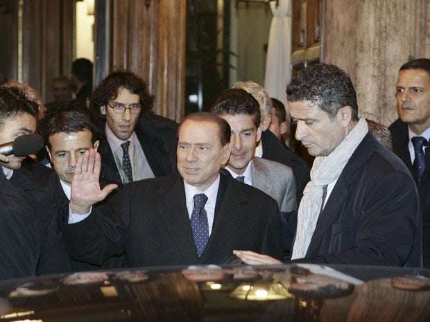 Silvio Berlusconi (centre) leaves after a meeting with his allies in the Italian Senate in Rome last night