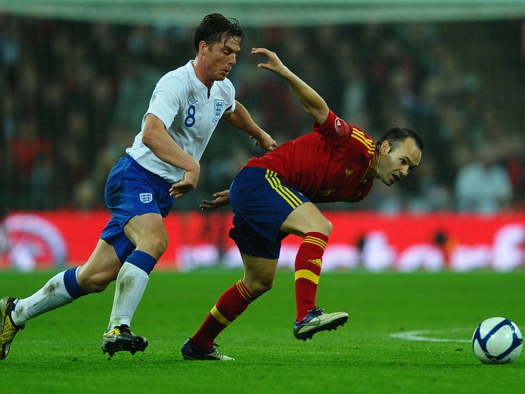 Andres Iniesta battles with England captain Scott Parker