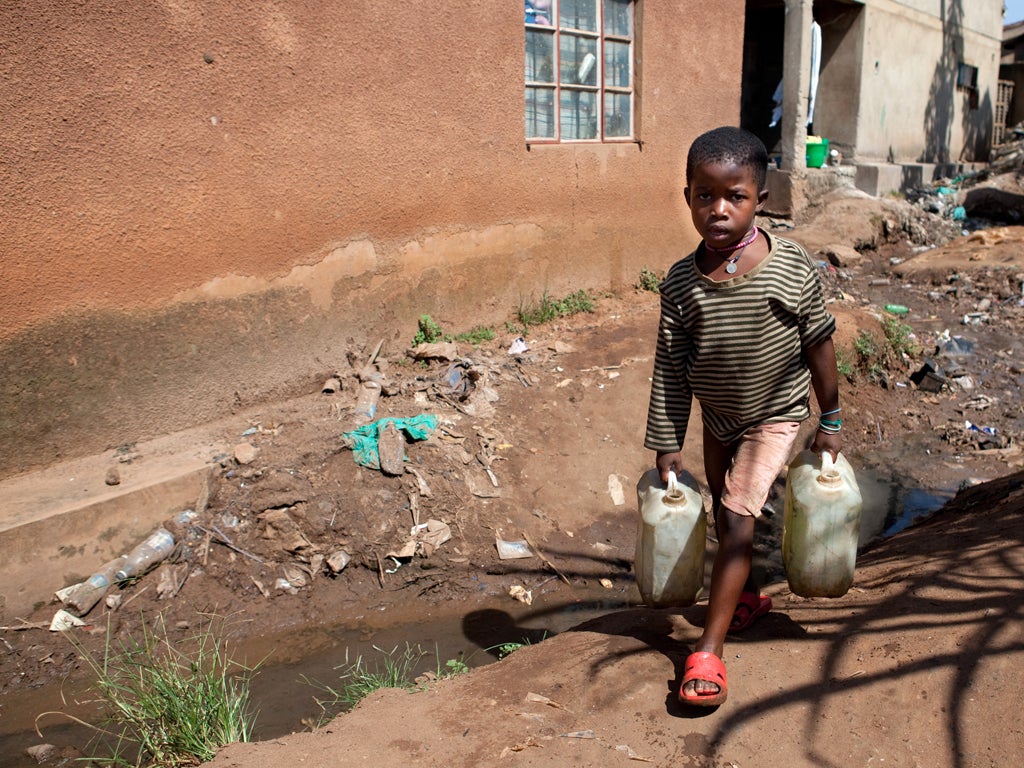 A child carrying water through the Kifumbira slum in Kampala, Uganda, where sanitation is scarce