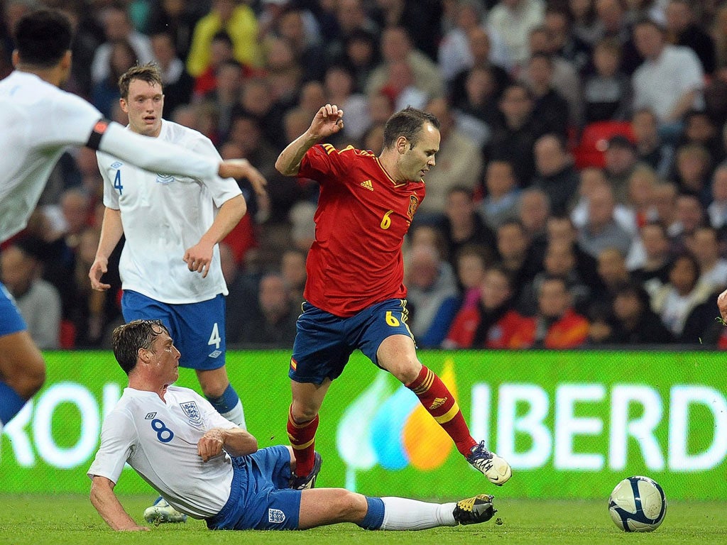 England's man of the match, Scott Parker, slides in to tackle Andres Iniesta