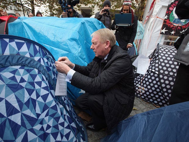 An eviction notice is attached to a tent by a City of London Corporation employee