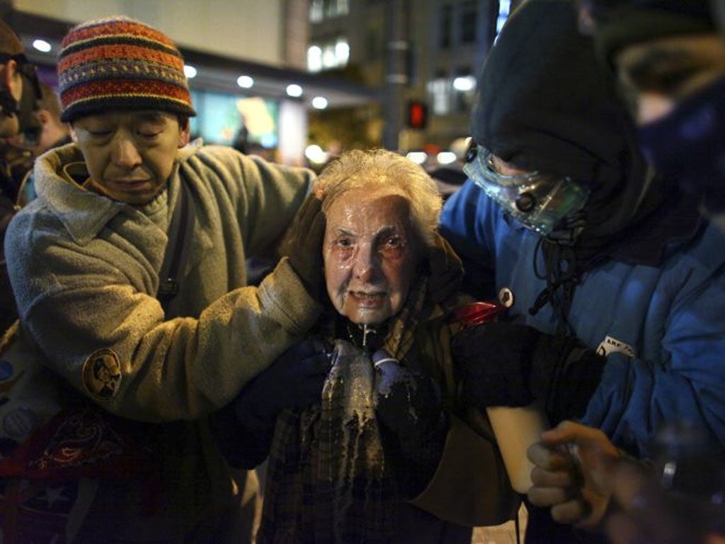 Seattle activist Dorli Rainey, 84, reacts after being hit with pepper spray during an Occupy Seattle protest